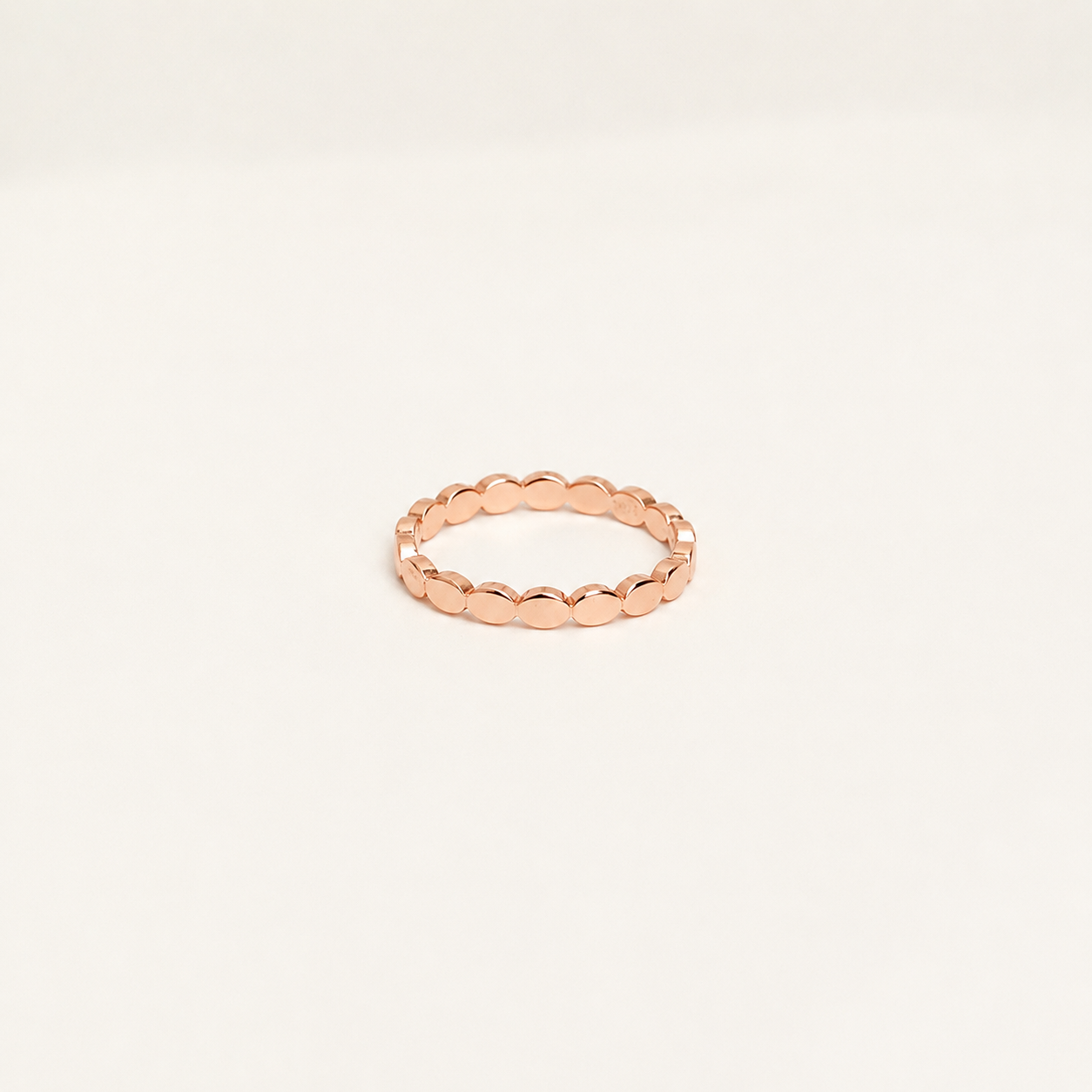 Rose gold ring on a light beige background
